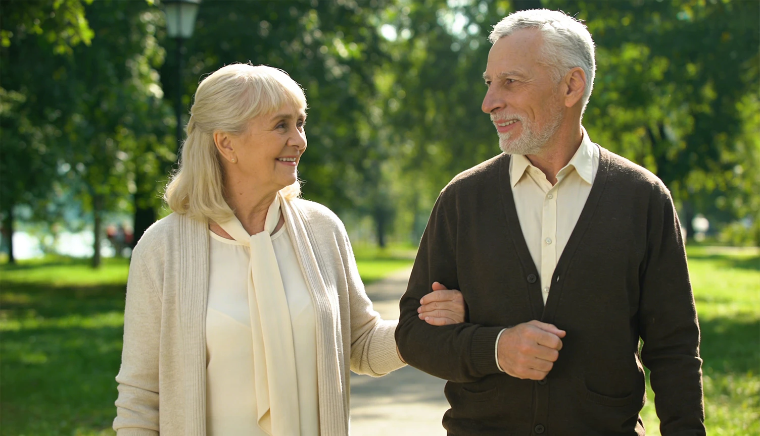 Elderly couple walking together in a park